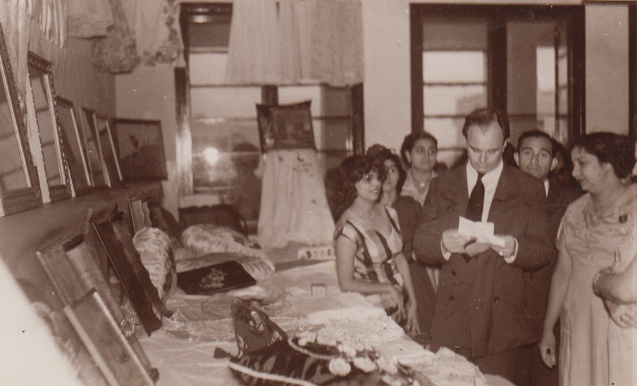 Prince Aly Khan reviewing notes and works of arts and crafts as well as needlework prepared by Ismaili students of Lourenço Marques during his visit to the Portuguese colonial city in 1958. Seen in the picture are the late Mrs. Hirbanoo Hussein (right) and Mrs. Maleksultan Merchant (left). Photo: Jehangir A. Merchant Collection.