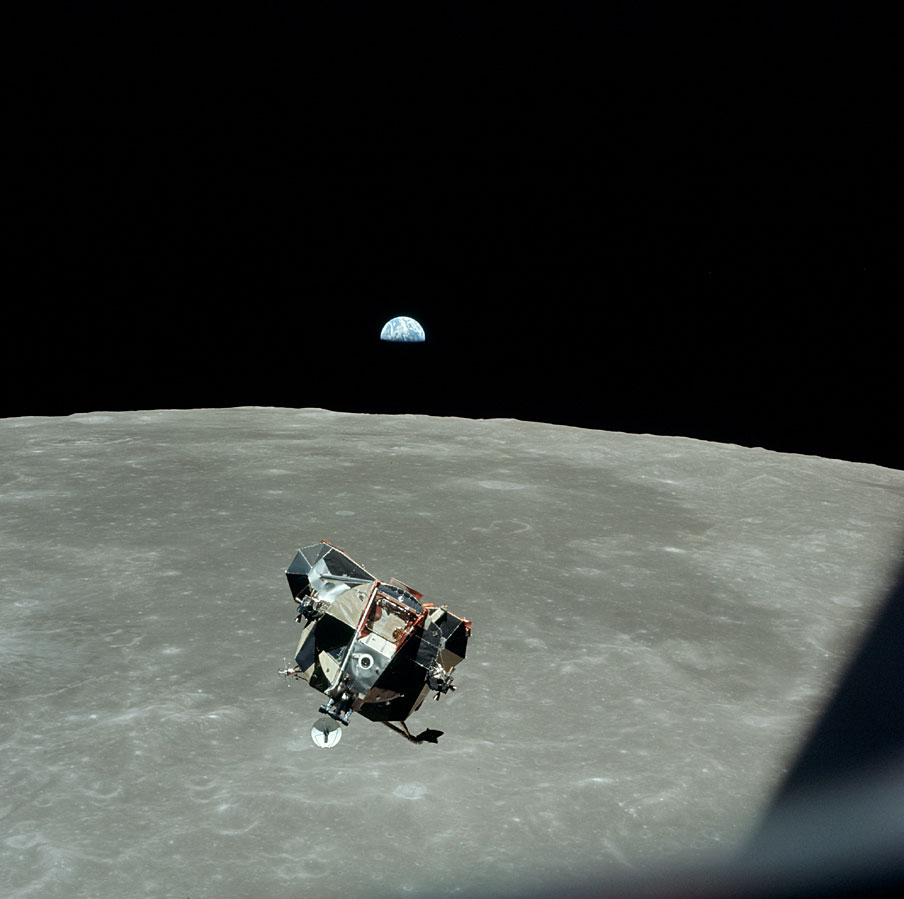 AS11-44-6642_LM approaches CSM for docking with earthrise in b.g.