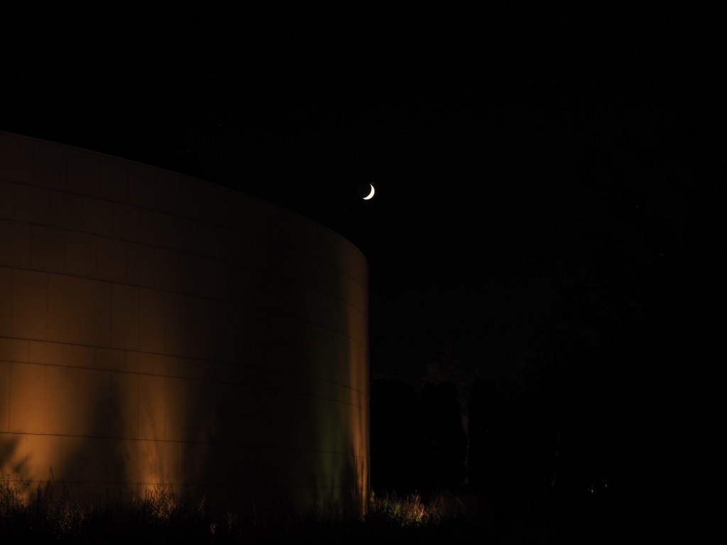 9:09 -10:40 PM: The Crescent Moon seen just above the circular wall of the Ismaili Jamatkhana on July 23, 2020. Photo: Malik Merchant / Simergphotos.