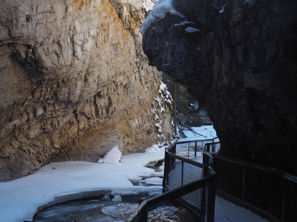 A pedestrian bridge underneath a canyon wall at Johnston Canyon